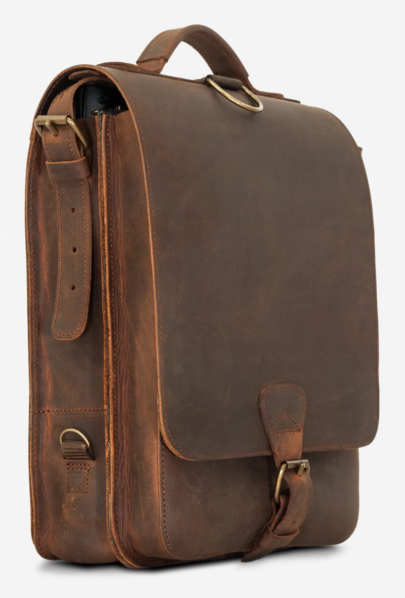 Side view of the vegetable-tanned brown leather backpack with shoulder belt.